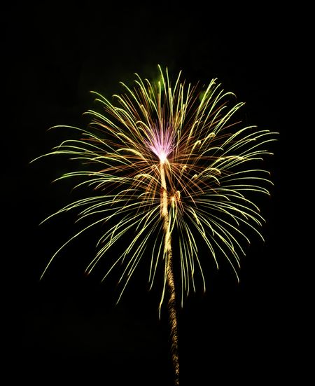 Yellow-green burst of fireworks with a pink flowery effect at its core