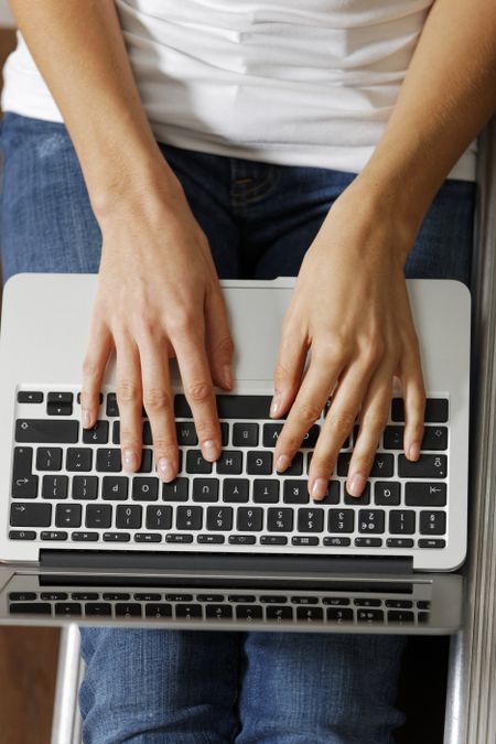 Woman's hands typing on a modern laptop computer