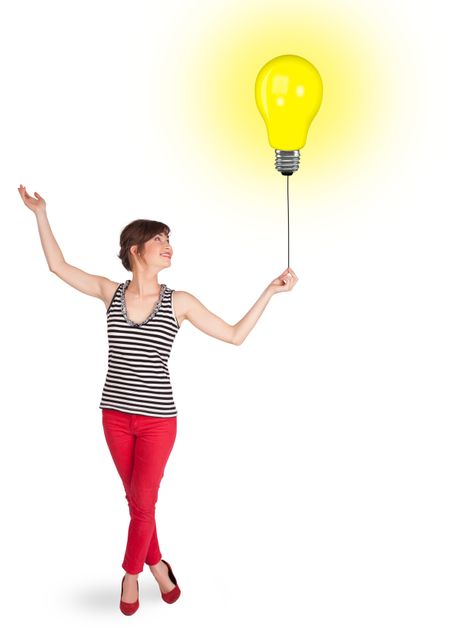 Happy young woman holding a light bulb balloon