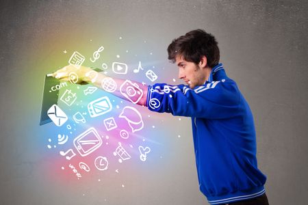 Casual young man holding laptop with colorful hand drawn multimedia symbols