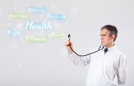 Elderly clinical doctor pointing to health and fitness collection of words