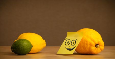 Lemon with sticky post-it note looking at citrus fruits