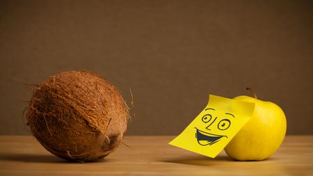 Apple with sticky post-it note looking happy at coconut