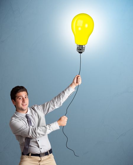 Handsome young man holding light bulb balloon