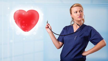 Pretty young nurse healing a red heart