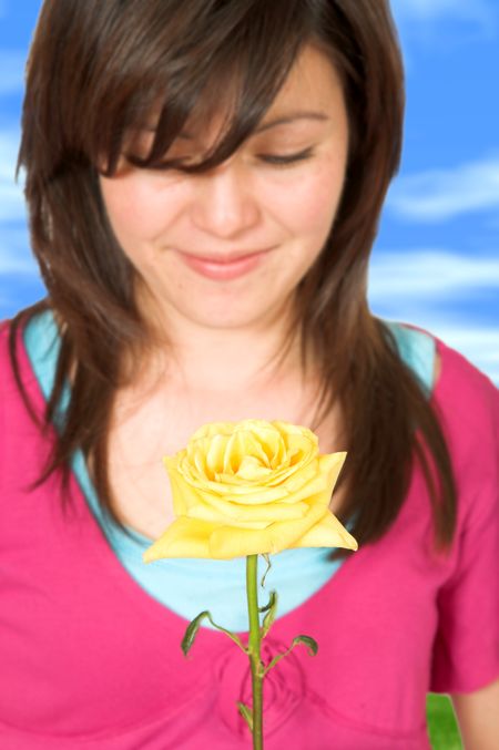 beautiful teenager with a yellow rose with a sky in the background - clipping path included for you to change the background easily if you wish