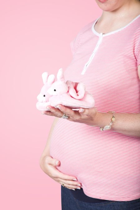 baby in the way - woman holding some cute rabbit shoes for the baby to be