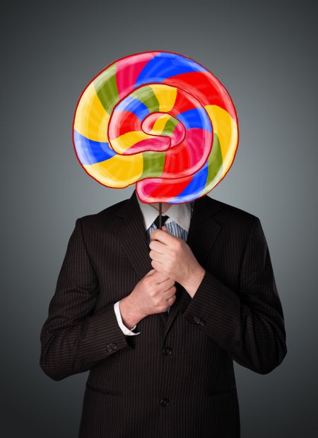 businessman-holding-colorful-striped-lollipop-front-166270958 Businessman holding a colorful striped lollipop in front of his head