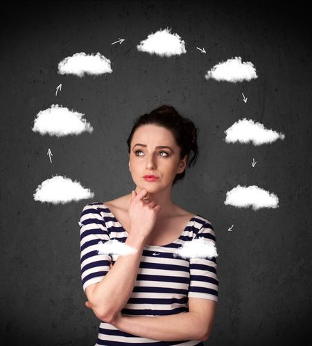 Thoughtful young woman with drawn clouds circulating around her head