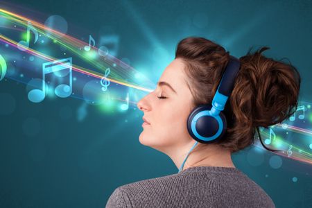 Pretty young woman with headphones listening to music, glowing notes and lines concept