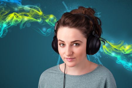 Pretty young woman with headphones listening to music, glowing smoke concept