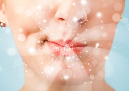 Pretty woman lips blowing abstract white lights - close up