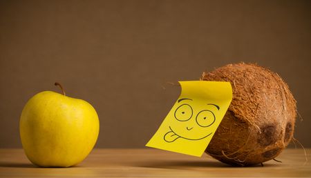 Coconut with sticky post-it note gesturing at apple