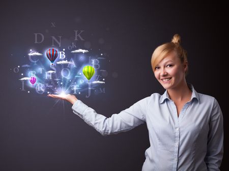 Young businesswoman holding shining letters and balloons in her hand