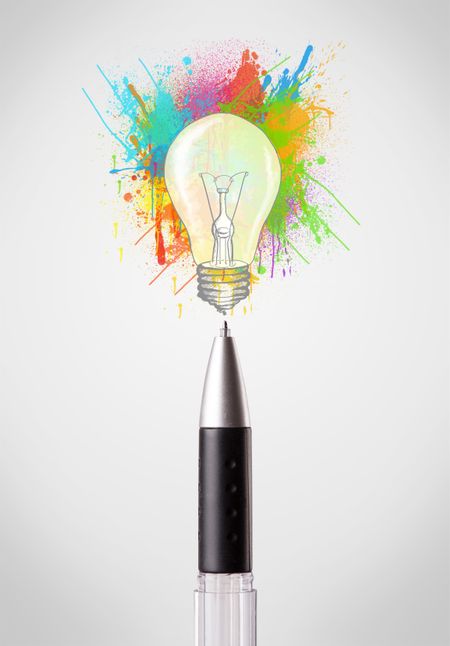Pen close-up with colored paint splashes and lightbulb concept