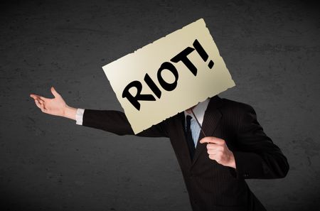 Businessman holding a demonstration board with riot sign in front of his head