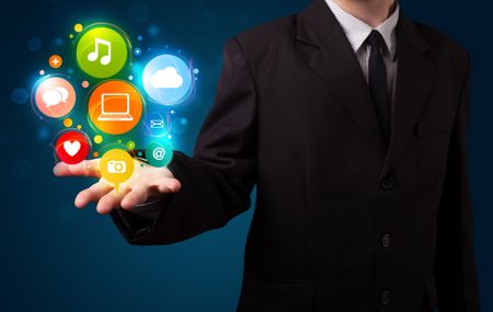 Young business man in suit presenting colorful technology icons and symbols