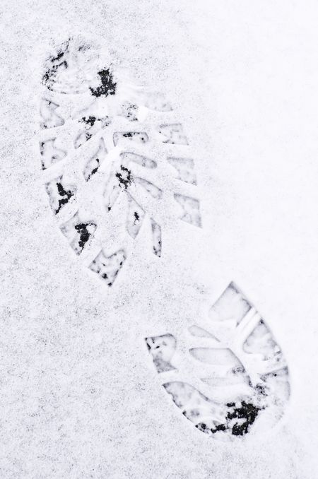 Winter at a glance: Footprint in light snow on path