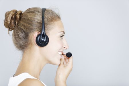 Attractive young woman using a telephone headset