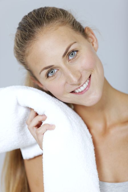 Beautiful young woman cooling off after exercising with a towel.