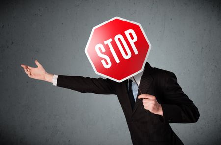 Businessman standing and holding a stop sign in front of his head