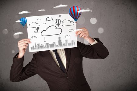 Businessman holding a cardboard in front of his head with cityscape and ballons drawing