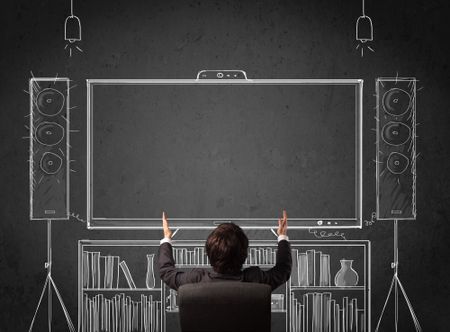 Young businessman sitting and enjoying home cinema system sketched on a chalkboard