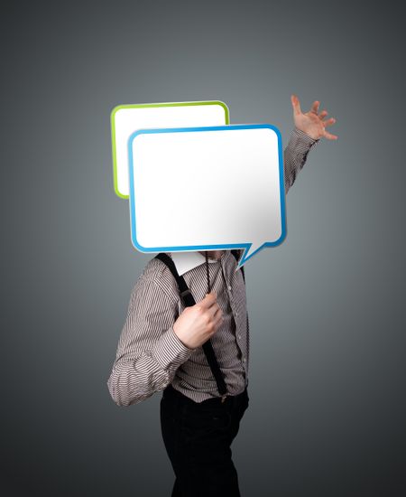 Businessman standing and holding an empty speech bubble in front of his head