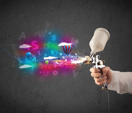 Worker with airbrush and colorful abstract clouds and balloons concept
