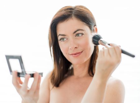 attractive woman in her forties applying makeup