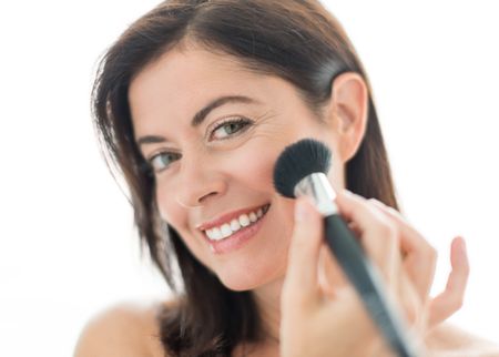 attractive woman in her forties applying makeup