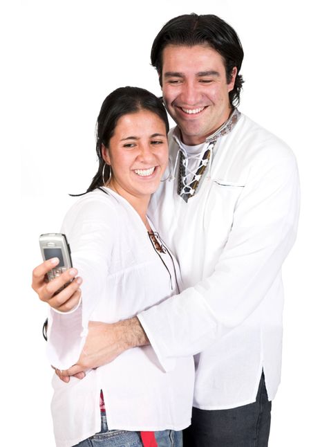 couple in white taking a photo of themselves