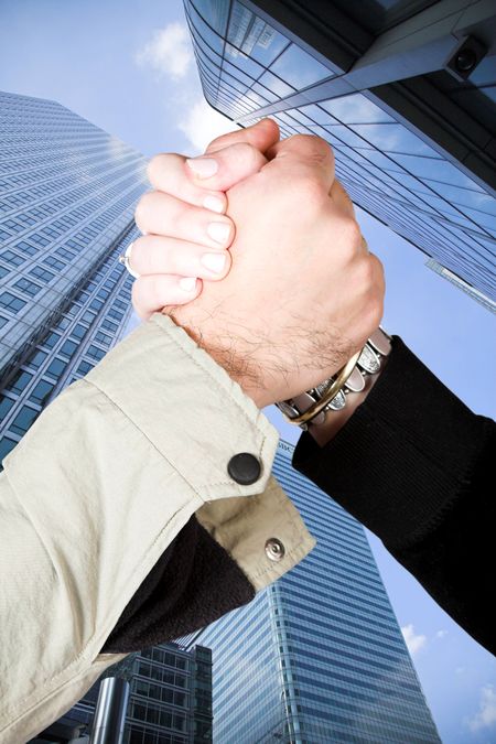 informal handshake over financial buildings