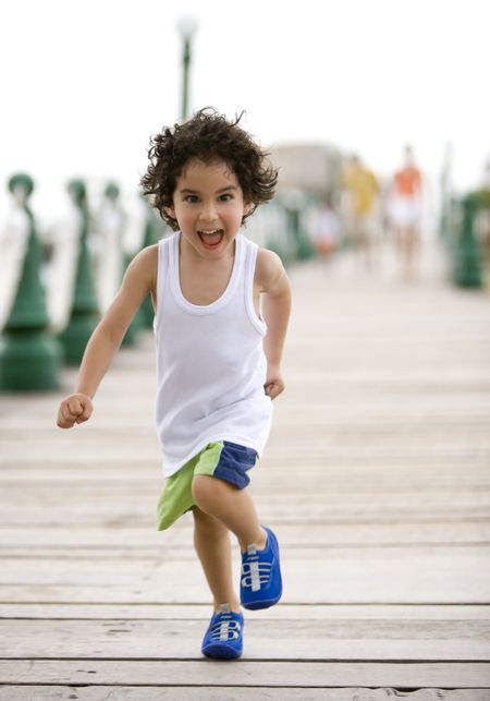 Happy kid running and having fun at the beach