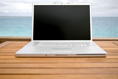 laptop computer outdoors on top of a table with the sky in the background
