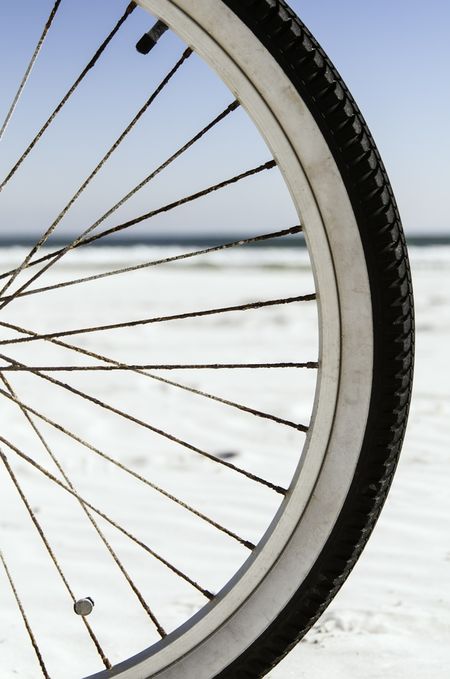 Mobility at the beach: Focus on front tire of bicycle, with horizon of Atlantic Ocean in background (shallow depth of field)