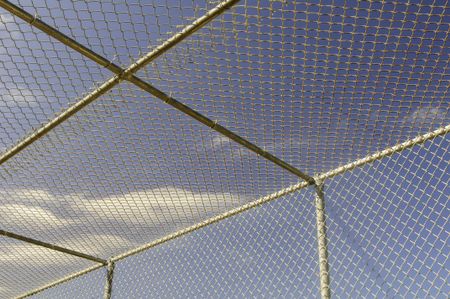 Part of batting cage by baseball field