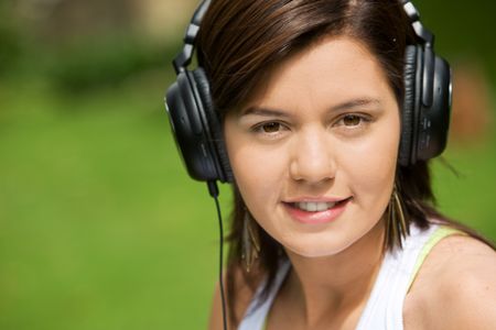 Girl listening to music looking happy - outdoors