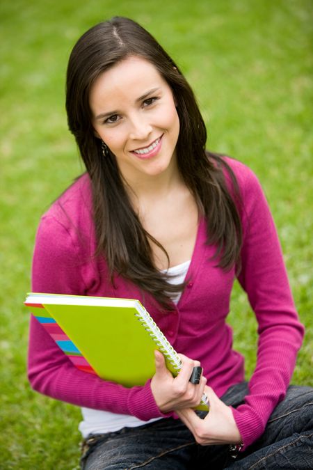 Beautiful girl holding notebooks - smiling outdoors