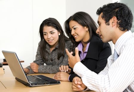 business team browsing on a laptop - smiling over a white background