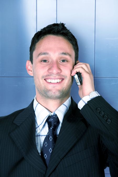 business man on the phone against a metal wall