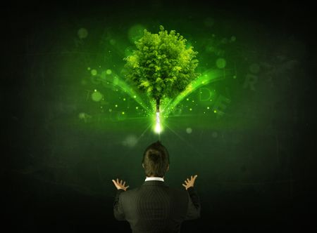young-businessman-standing-glowing-tree-letters-180625319 Young businessman standing with a glowing tree and letters above his head