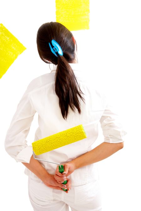 girl painting a wall with a yellow rolling pin isolated over a white background