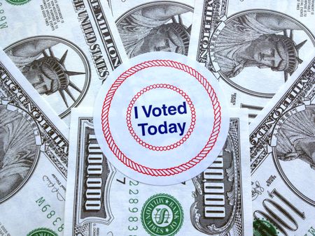 It pays to vote: Proclamatory sticker on a pile of fake million-dollar bills (play money)