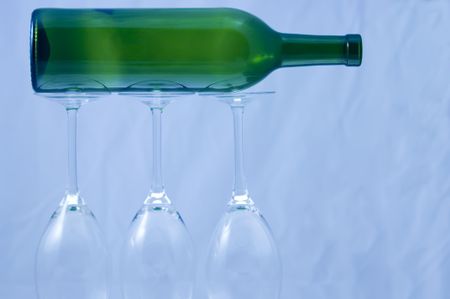 Wine bottle supported by three wine glasses