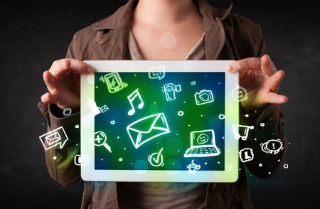 Person holding a white tablet with media icons and symbols