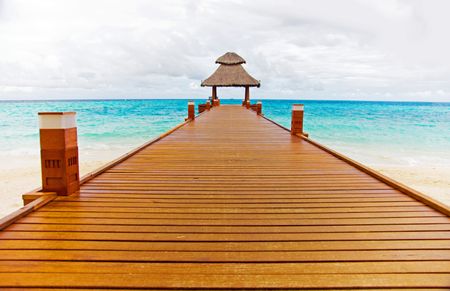 beach deck with a hut at the end of the wooden path