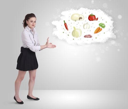 Pretty woman presenting a cloud of healthy nutritional vegetables concept