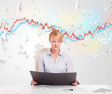 Business woman sitting at table with stock market graph 3d letters 