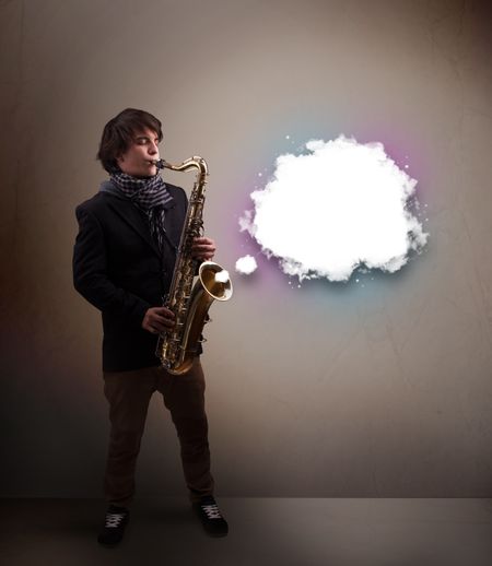 Handsome young man playing on saxophone with copy space in white cloud